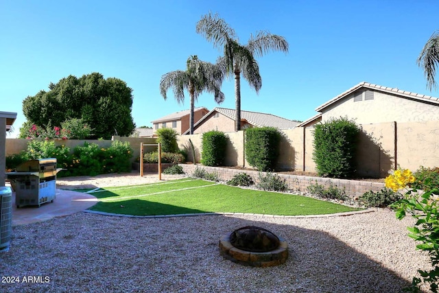 view of yard with a fire pit and central AC unit