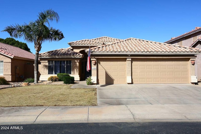 mediterranean / spanish house featuring a front yard and a garage