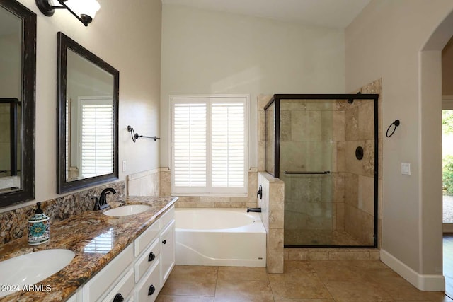 bathroom featuring tile patterned flooring, vanity, separate shower and tub, and vaulted ceiling