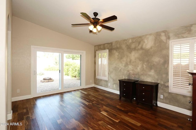 unfurnished room with plenty of natural light, ceiling fan, dark hardwood / wood-style flooring, and vaulted ceiling