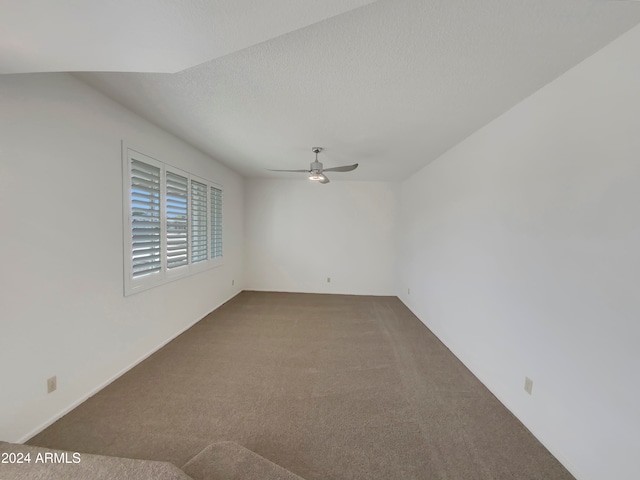 empty room with ceiling fan, carpet, and a textured ceiling