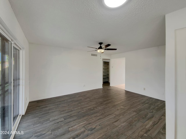 empty room with dark hardwood / wood-style floors, a textured ceiling, and ceiling fan