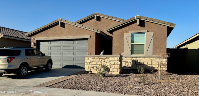 single story home featuring a garage, concrete driveway, and stucco siding