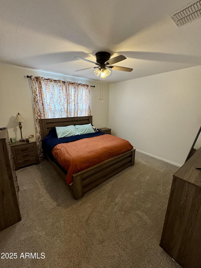 bedroom featuring a ceiling fan, carpet, visible vents, and a textured ceiling