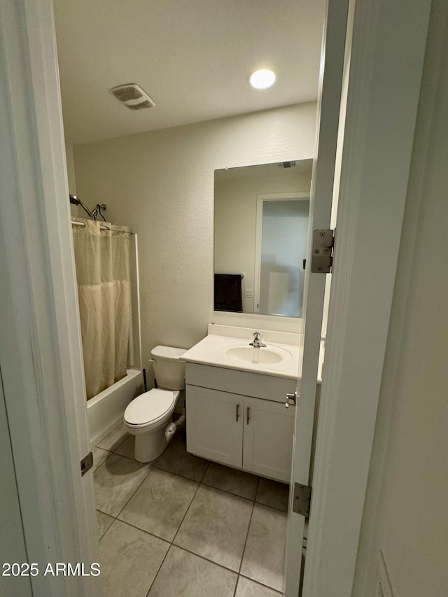 full bath with tile patterned flooring, toilet, vanity, visible vents, and shower / bath combo