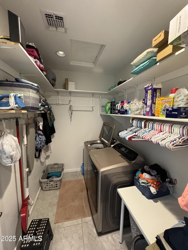 clothes washing area with washer and clothes dryer, light tile patterned floors, visible vents, attic access, and laundry area