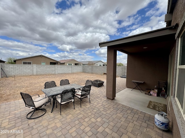 view of patio / terrace featuring outdoor dining space, an outdoor fire pit, and a fenced backyard