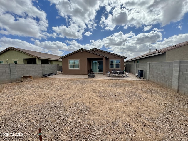 rear view of property featuring a patio area, a fenced backyard, and stucco siding