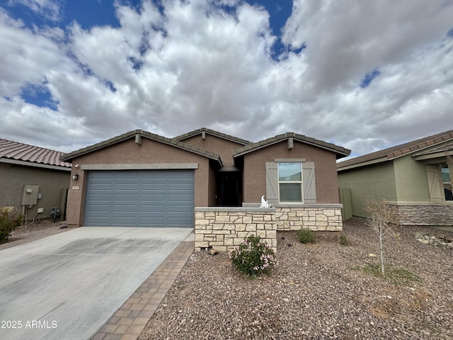 single story home with stone siding, driveway, an attached garage, and stucco siding