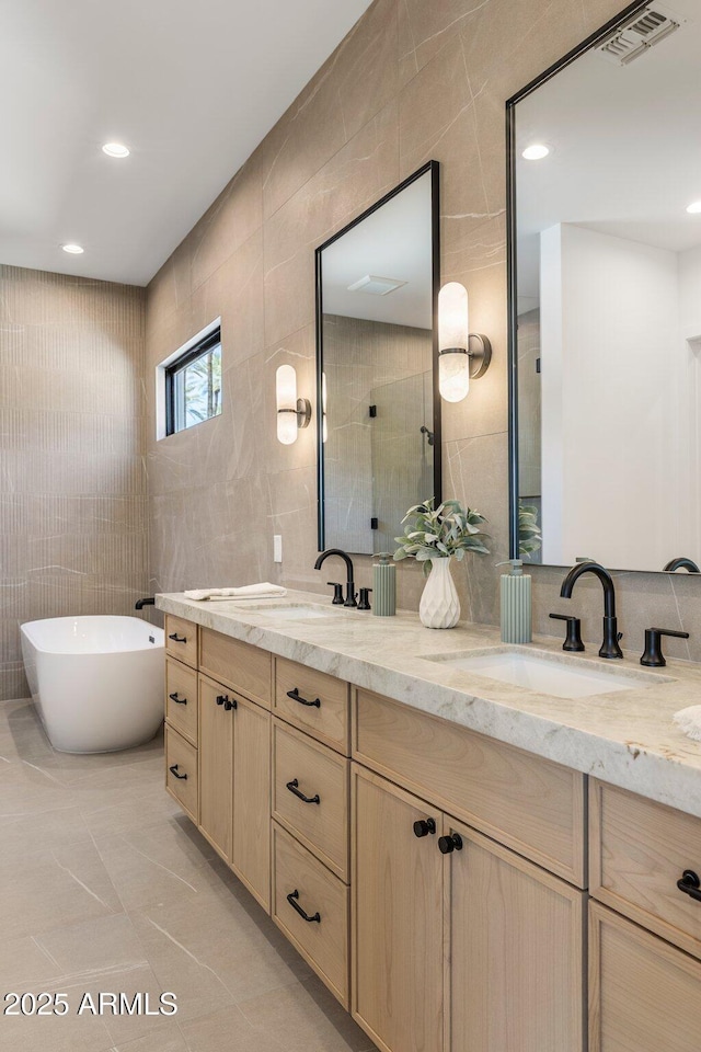 4301 E Sells Dr, Phoenix, AZ 85018 - full bath with tile walls, double vanity, a soaking tub, recessed lighting, and tiled shower