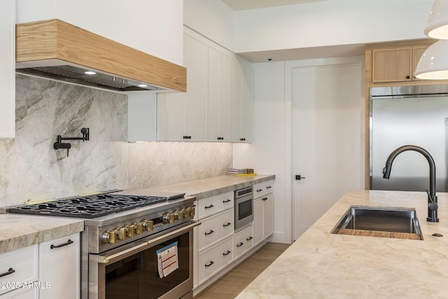 4301 E Sells Dr, Phoenix, AZ 85018 - kitchen with high end stainless steel range, custom exhaust hood, a sink, backsplash, and light wood-style flooring