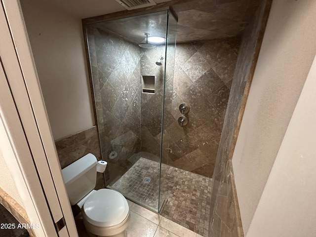 9476 E Laurel Ln, Scottsdale, AZ 85260 - bathroom featuring a tile shower, toilet, and tile patterned floors