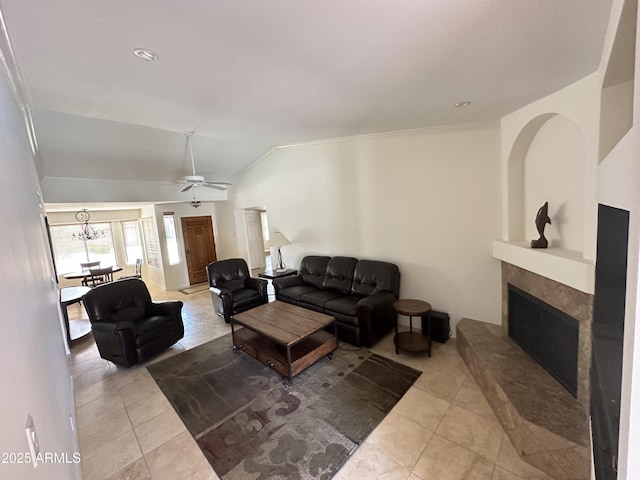 9476 E Laurel Ln, Scottsdale, AZ 85260 - tiled living room featuring ceiling fan, a fireplace with raised hearth, vaulted ceiling, and ornamental molding