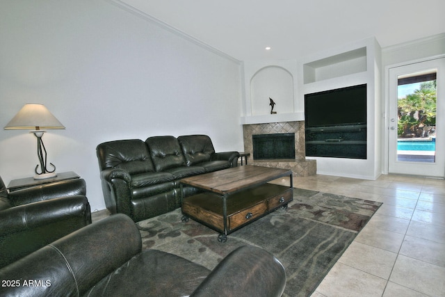 9476 E Laurel Ln, Scottsdale, AZ 85260 - living room featuring tile patterned flooring, ornamental molding, a tiled fireplace, built in shelves, and baseboards