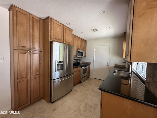 9476 E Laurel Ln, Scottsdale, AZ 85260 - kitchen featuring stainless steel appliances, a sink, brown cabinets, dark countertops, and recessed lighting