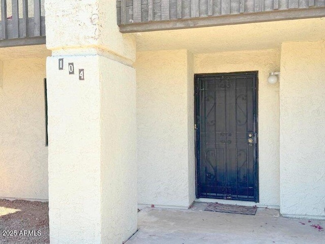 entrance to property featuring stucco siding