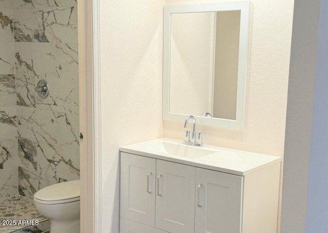 full bathroom with toilet, a marble finish shower, and vanity