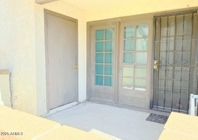 entrance to property featuring stucco siding