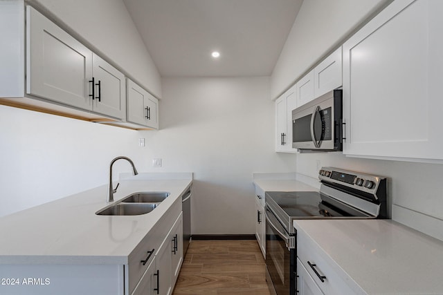 kitchen with white cabinets, dark hardwood / wood-style flooring, stainless steel appliances, and sink