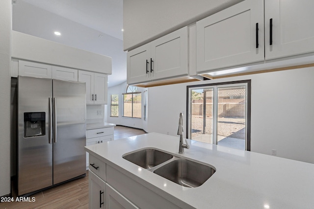 kitchen featuring stainless steel fridge with ice dispenser, light wood-type flooring, white cabinetry, and sink