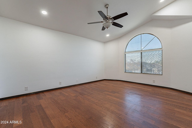 empty room with dark hardwood / wood-style floors, ceiling fan, and vaulted ceiling