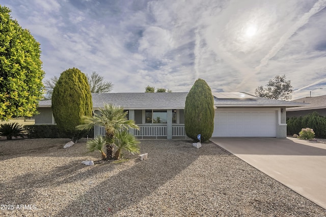 view of front of property featuring a garage, concrete driveway, roof with shingles, and stucco siding