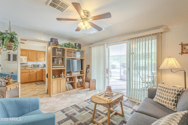 living area with lofted ceiling, ceiling fan, and visible vents