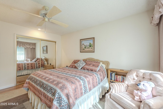 bedroom featuring a ceiling fan, a closet, a textured ceiling, and wood finished floors