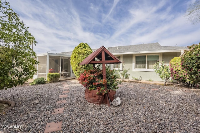 rear view of property with a sunroom and stucco siding