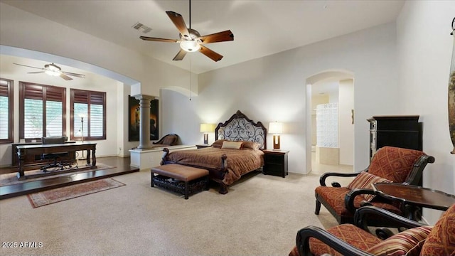 carpeted bedroom featuring connected bathroom, ceiling fan, and ornate columns