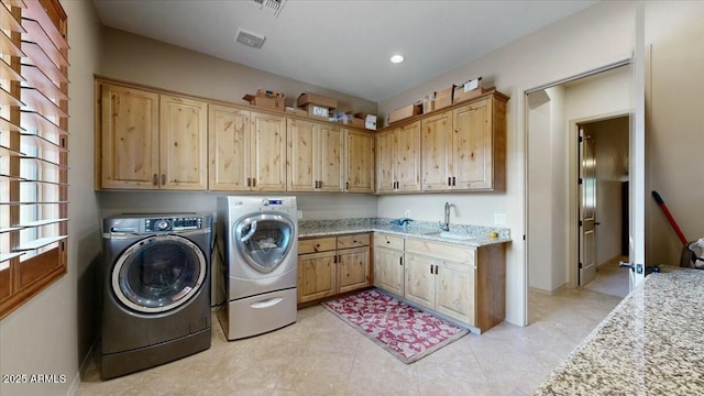 laundry area featuring cabinets, sink, and washer and dryer