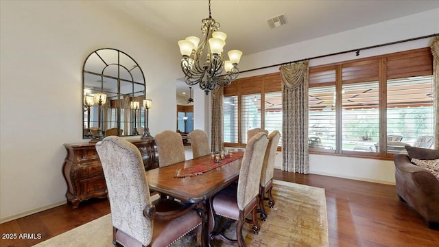 dining area featuring dark hardwood / wood-style flooring and a chandelier