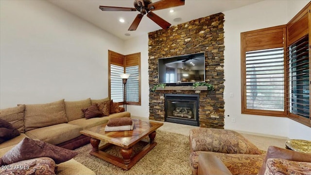 living room featuring a stone fireplace and ceiling fan