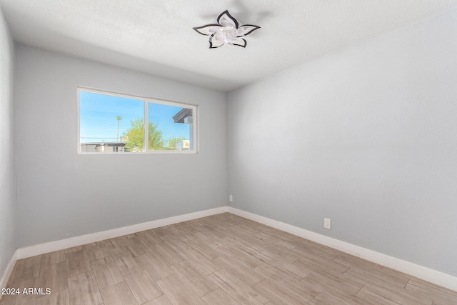 empty room featuring light hardwood / wood-style floors and a textured ceiling