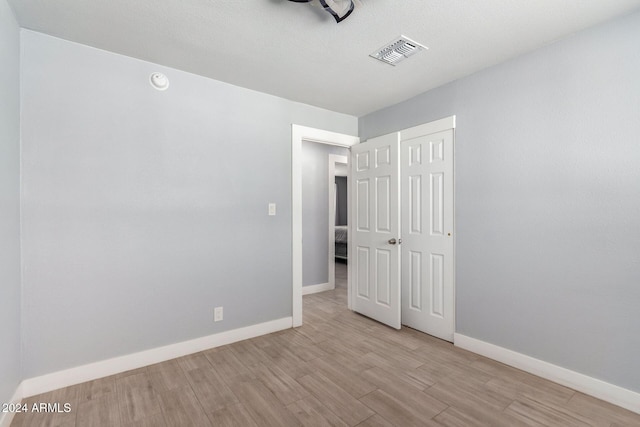 unfurnished bedroom featuring light hardwood / wood-style flooring and a textured ceiling