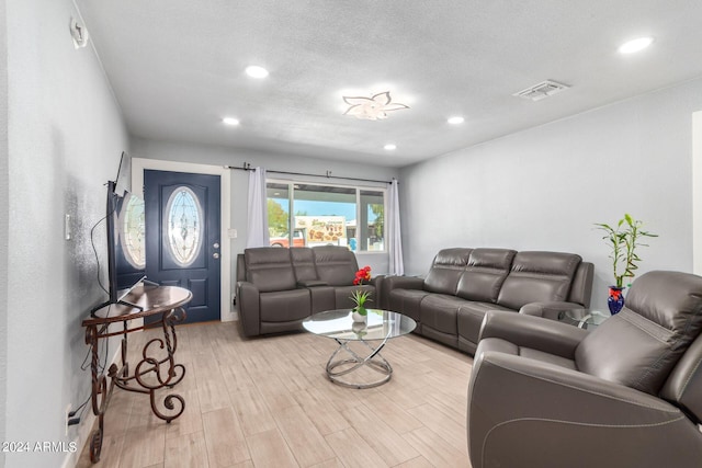 living room featuring a textured ceiling and light wood-type flooring