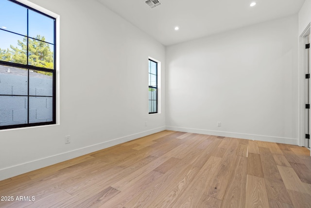 spare room with a healthy amount of sunlight, baseboards, recessed lighting, and light wood finished floors