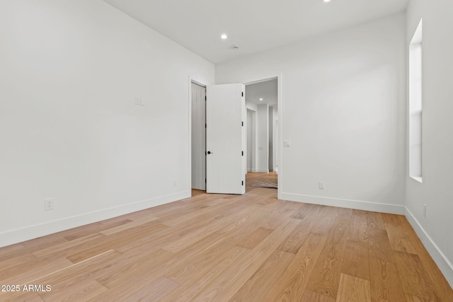empty room featuring recessed lighting, light wood-style floors, and baseboards