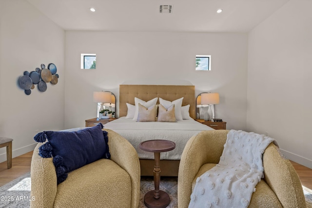 bedroom featuring baseboards, multiple windows, and wood finished floors