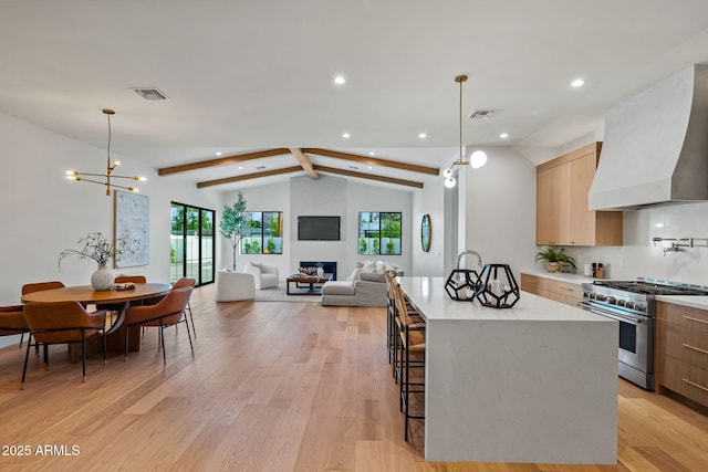 kitchen featuring modern cabinets, lofted ceiling with beams, custom range hood, and high end range
