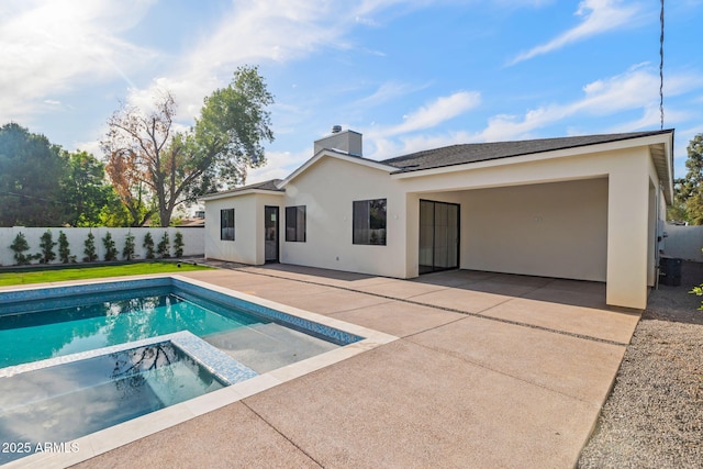 back of property featuring a chimney, a fenced backyard, a patio area, and stucco siding