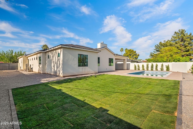 rear view of property with a lawn, a patio area, a fenced in pool, a fenced backyard, and stucco siding