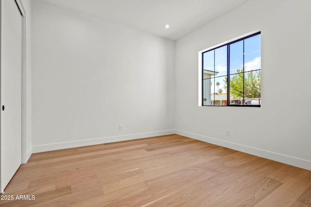 spare room featuring baseboards, recessed lighting, and light wood-style flooring