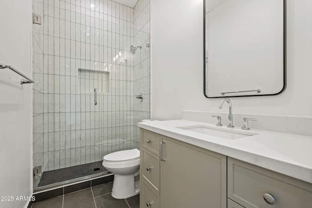 bathroom featuring vanity, toilet, tile patterned flooring, and a stall shower