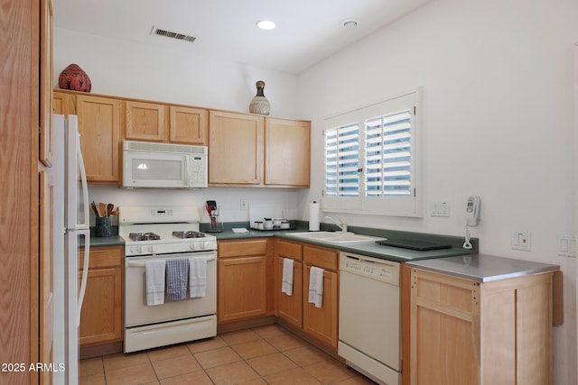 kitchen featuring sink, light tile patterned flooring, and white appliances