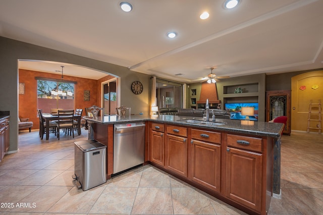 kitchen featuring dishwasher, sink, dark stone counters, hanging light fixtures, and ceiling fan