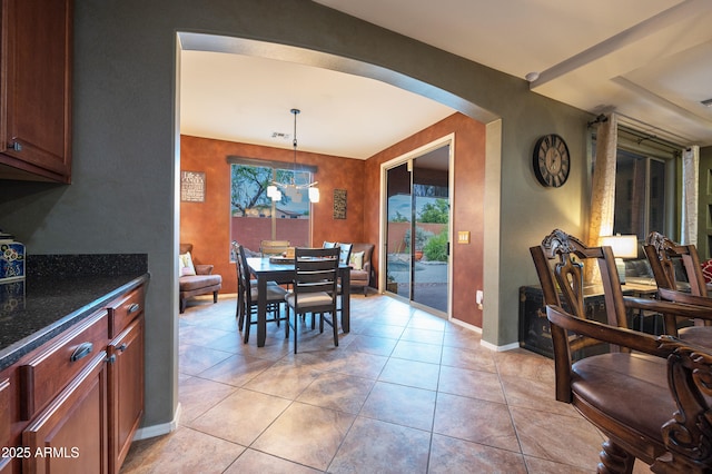 dining area with light tile patterned floors and an inviting chandelier