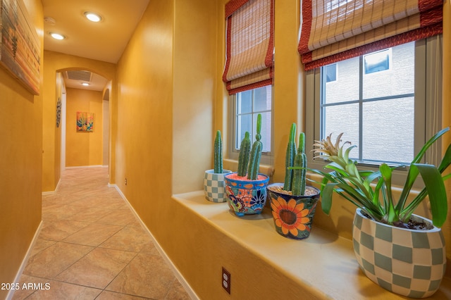 hallway featuring plenty of natural light and light tile patterned floors