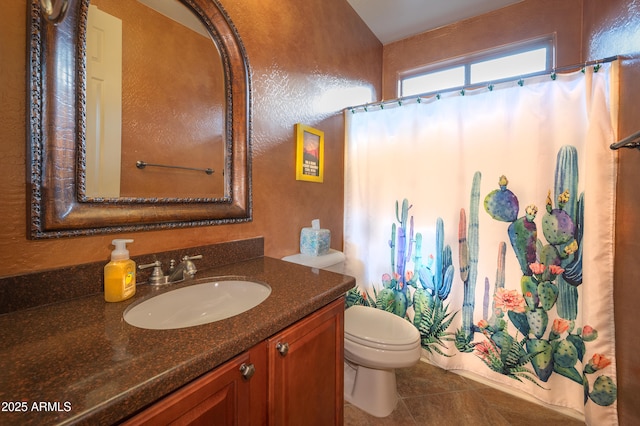 bathroom with tile patterned flooring, vanity, walk in shower, and toilet