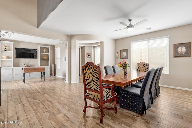 dining space with ceiling fan and light wood-type flooring